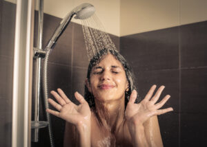 Jente som dusjer under kjølig vann.
