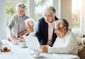 4 eldre kvinner ser på PCer sammen.