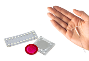 P-pillebrett, kondom og kondompakke, hormonspisal på hånsoverflate.